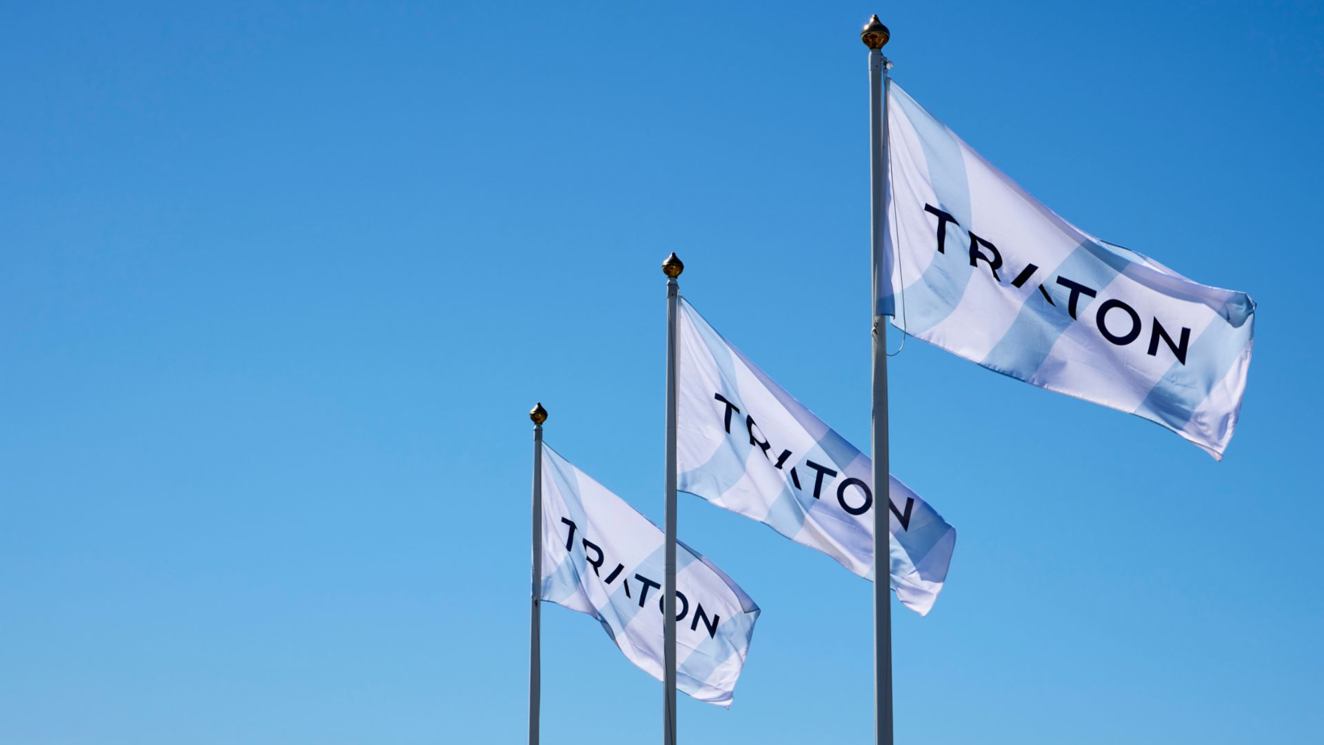 three company flags with the logo of TRATON