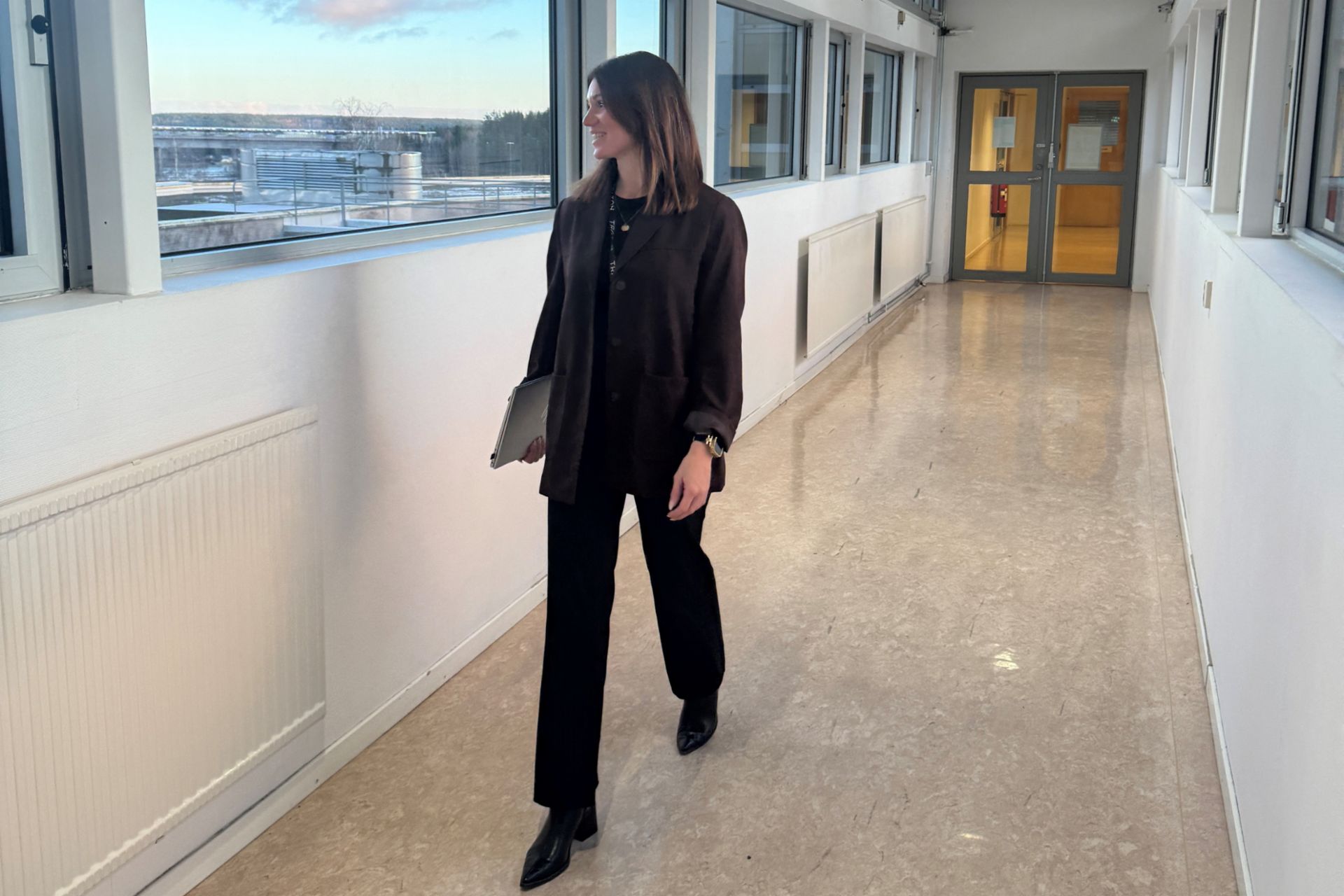  Eine Frau läuft einen langen Flur entlang. 