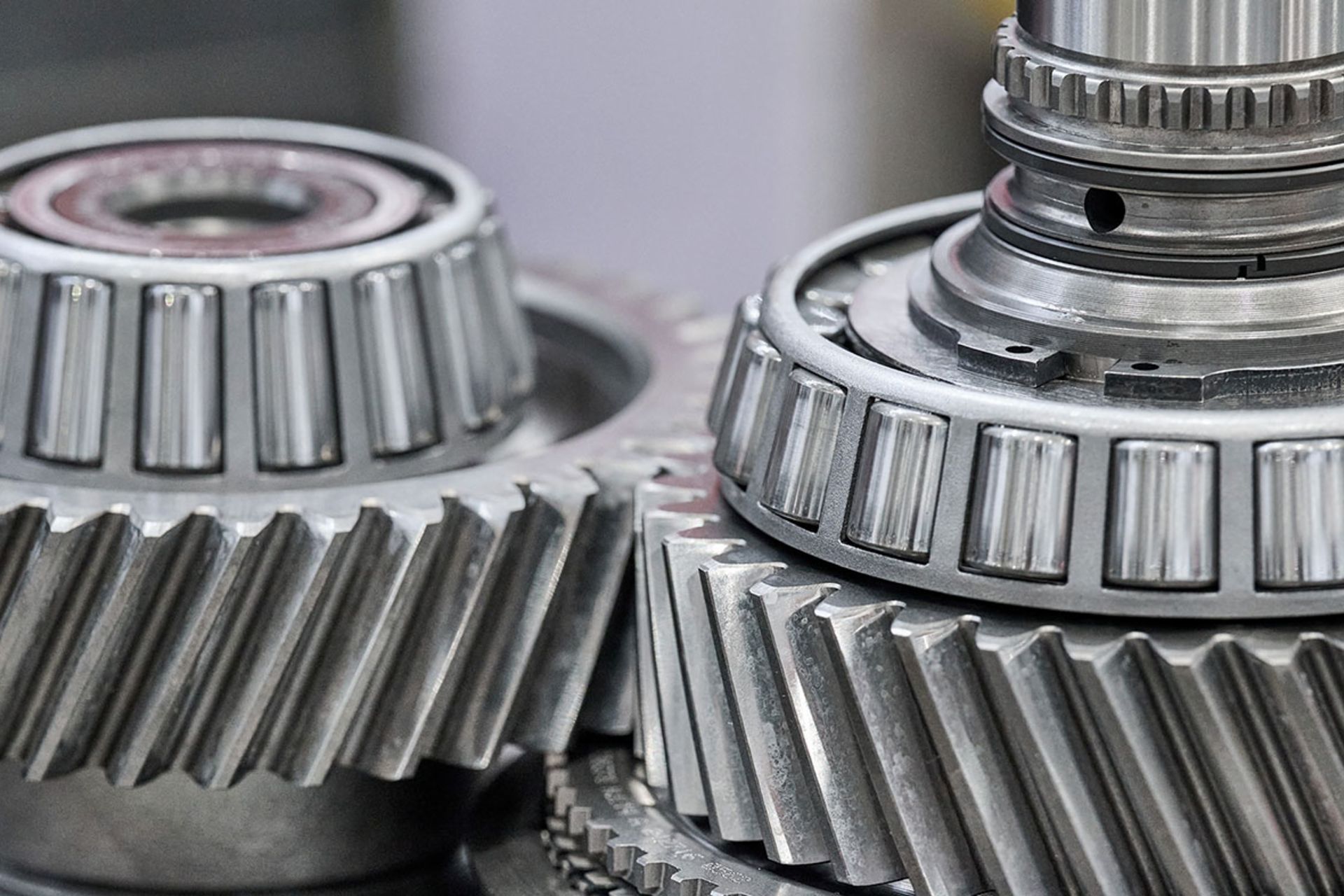 Detailed view of industrial cogwheels and tapered roller bearings in a mechanical assembly.
                 