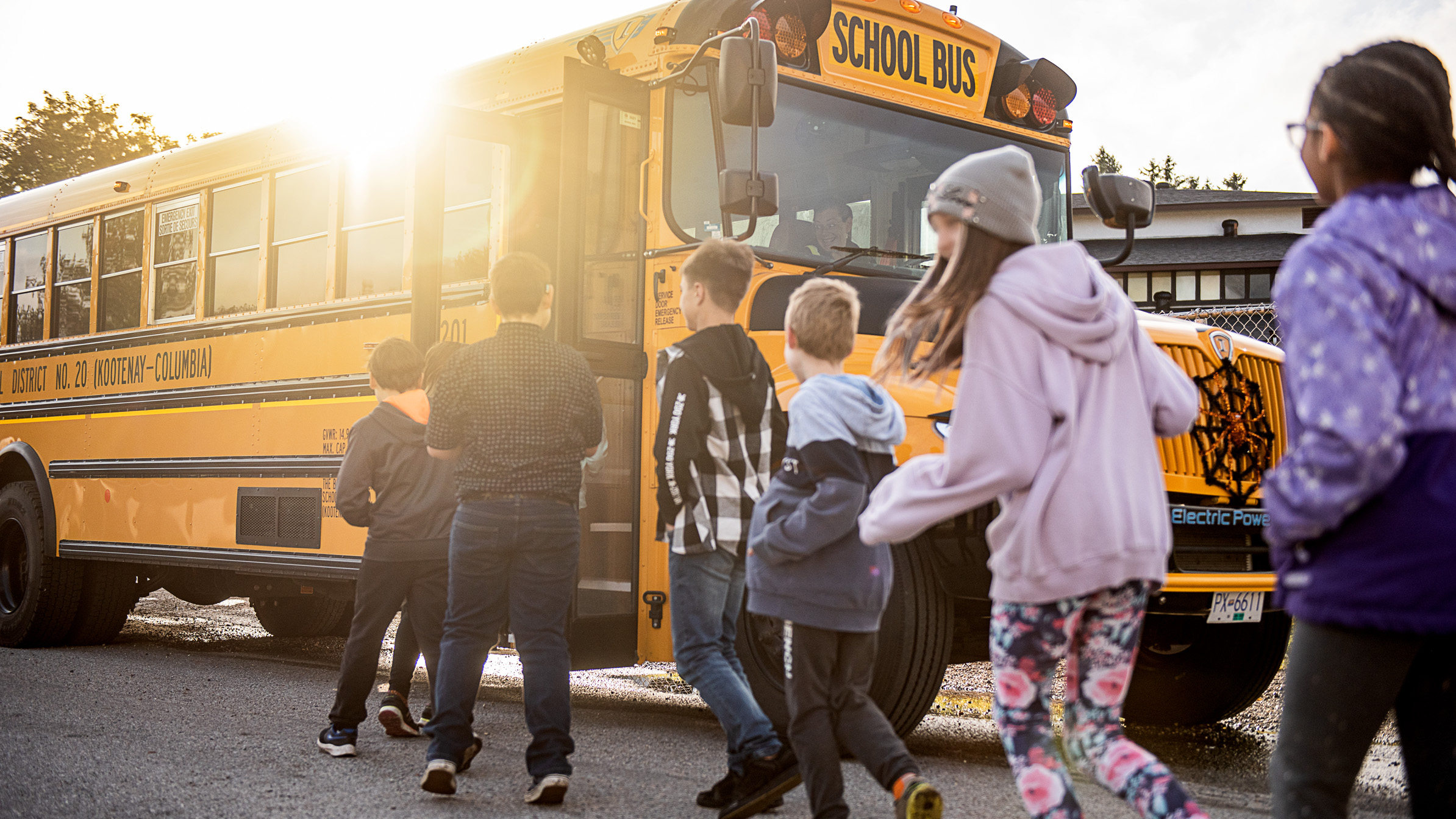 Kinder betreten den elektrischen Schulbus